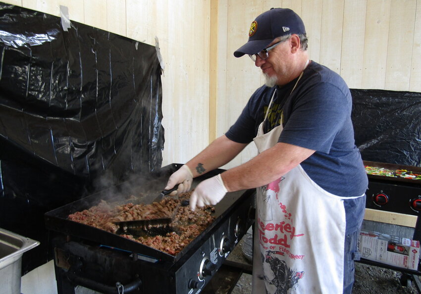 Phil Bassist with Square Peg Catering cooks carne asada for burritos available at the burro race.